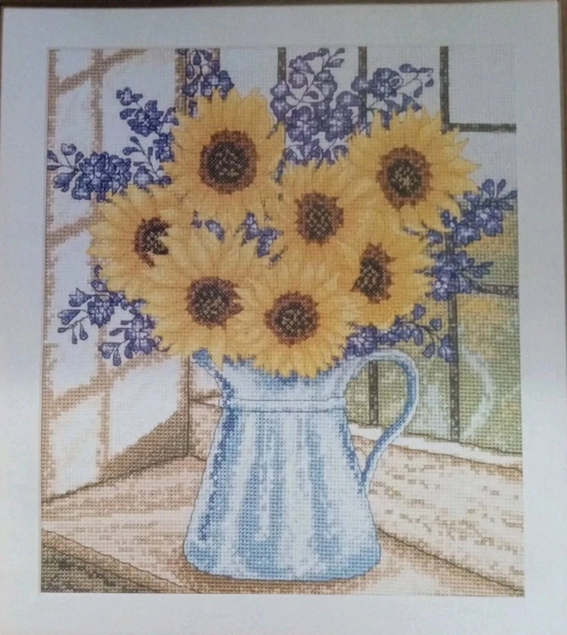 Sunflower bouquet cross-stitch pattern with blue pitcher and window, floral chart on fabric