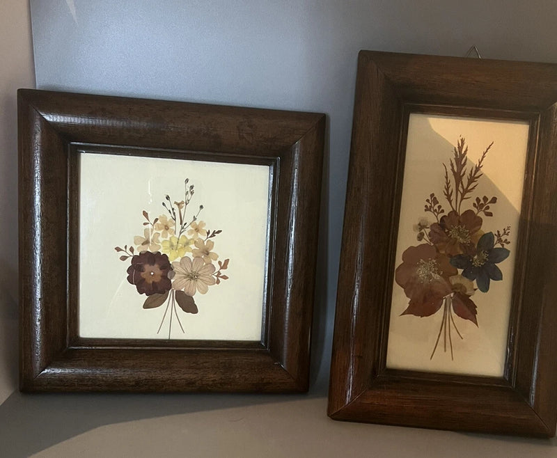 Wood-framed pressed flower art with bouquet of dried blooms on cream background