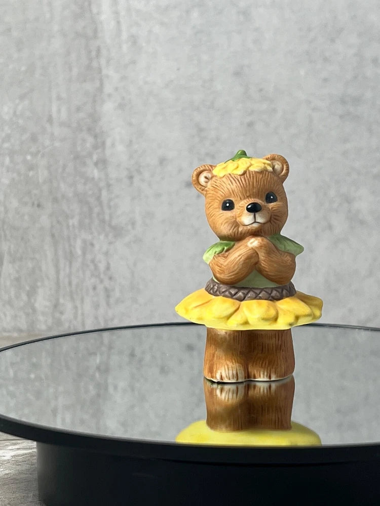 Garden sunflower bear figurine with yellow flower hat and brown standing base.