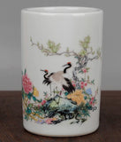 White porcelain brush pot with painted crane, tree, and peony flowers around the sides