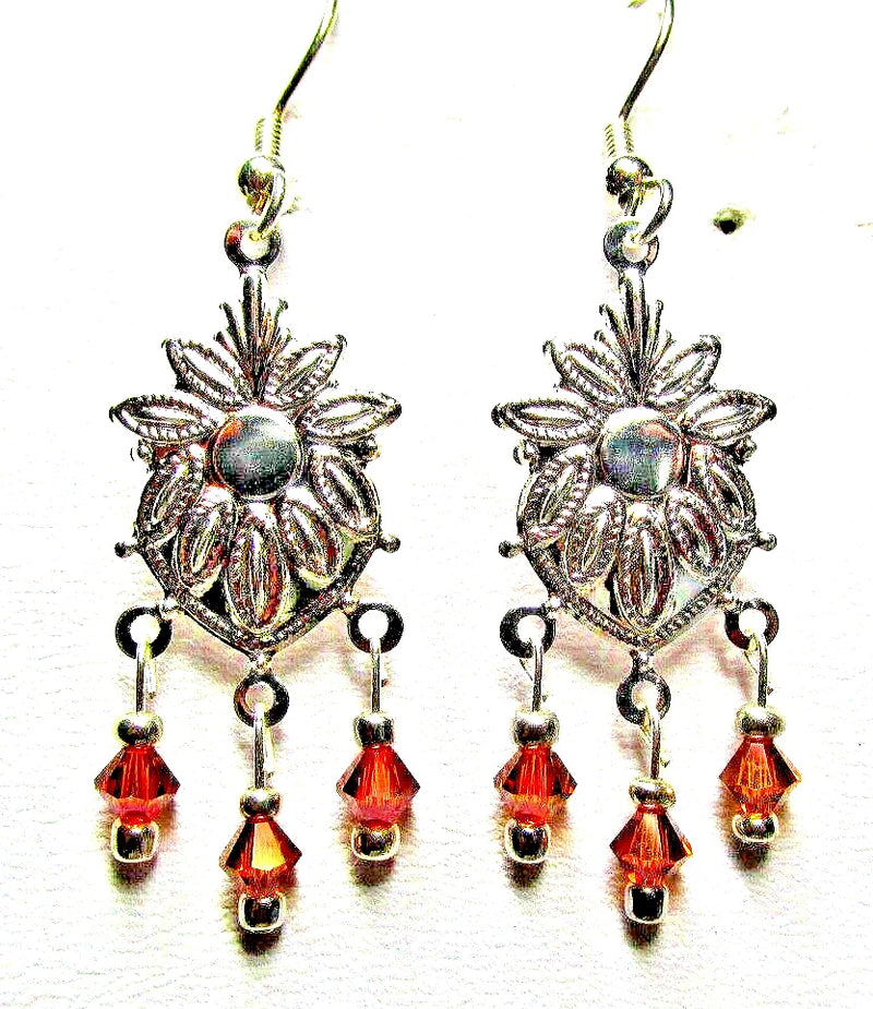 Silver sunflower chandelier earrings with red crystal drops and dangling bead accents