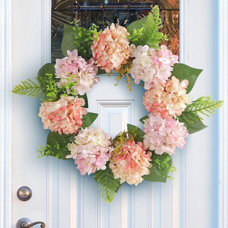 Artificial spring flower wreath with pink and peach blooms and green leaves