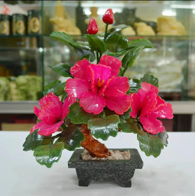 Decorative bonsai tree with pink-red peony flowers, green leaves, and dark stone base