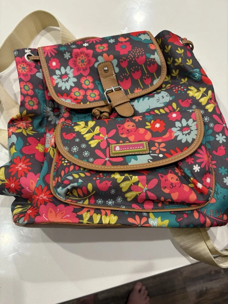 Teal floral cat backpack with top flap and front pocket, brown straps and trim