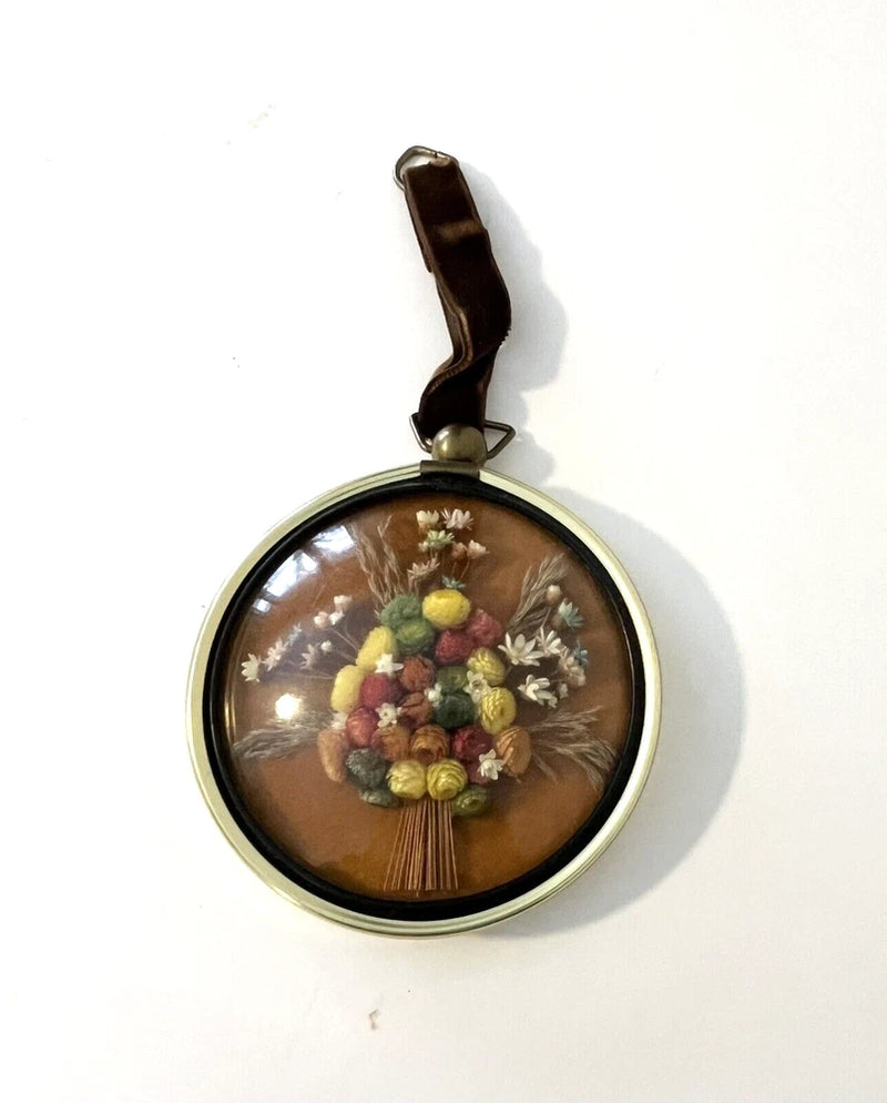 Round dried flower wall art with glass dome and gold-tone hanger, mixed pastel blooms
