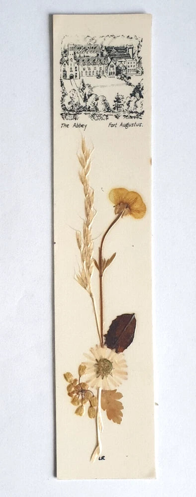 Pressed flower bookmark with dried blooms and an illustration panel on beige backing