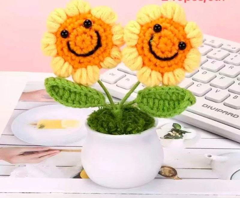 Set of crocheted sunflower potted flowers with two smiling blooms in a white pot