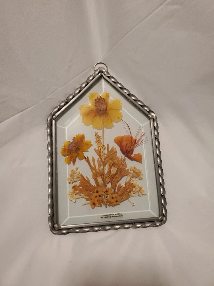 Arched glass framed pressed dried flowers wall decor with orange and yellow blooms
