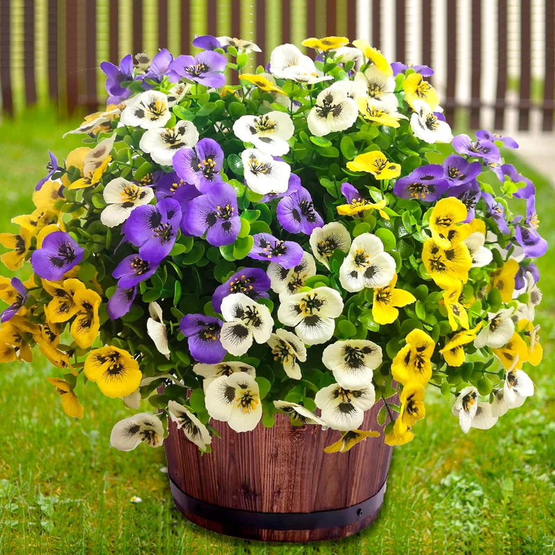 Outdoor artificial flower planter with purple, yellow, and white blooms and green leaves