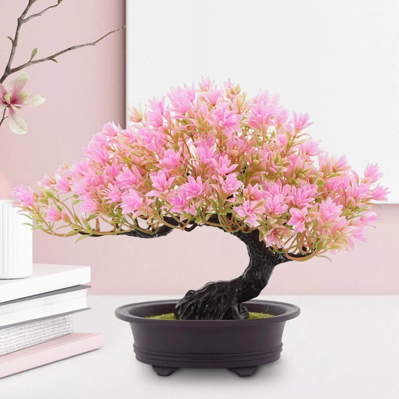 Artificial bonsai tree with pink blossoms in a black pot