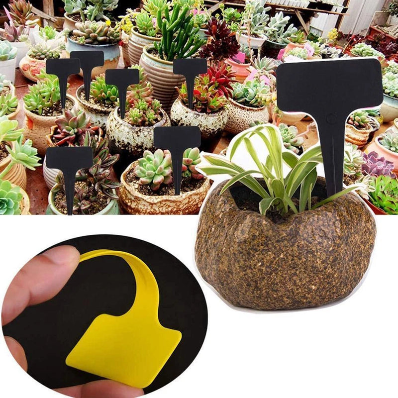 Black garden plant label stake marker with yellow icon, shown with a hand