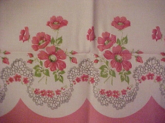Pink carnation border print fabric with floral and lace-style trim pattern