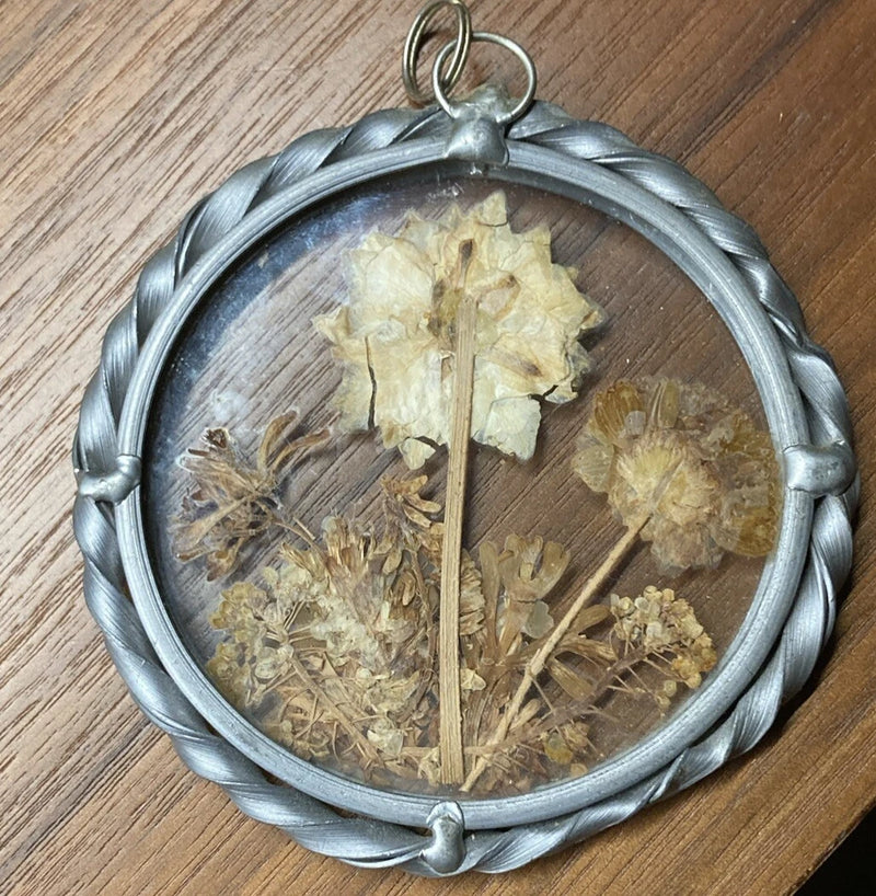 Round glass pendant with silver metal frame, pressed dried flowers in pale yellow and brown