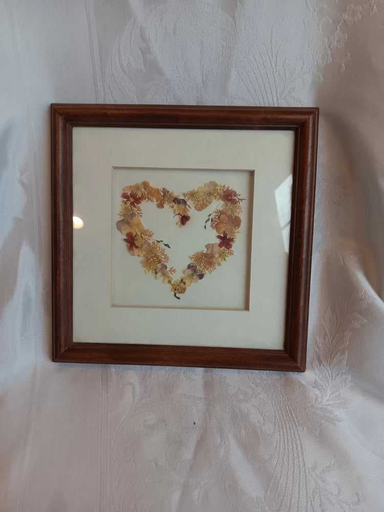 Framed heart-shaped dried flower wall art with brown wood frame