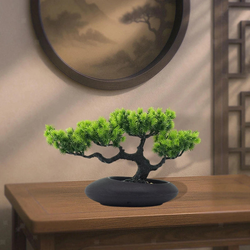 Small artificial bonsai tree with green foliage in a dark stone-style pot