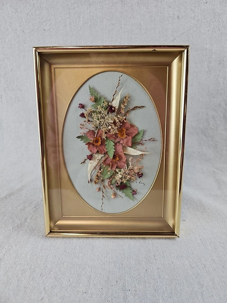 Gold-framed oval glass display of pressed dried flower bouquet, vintage style