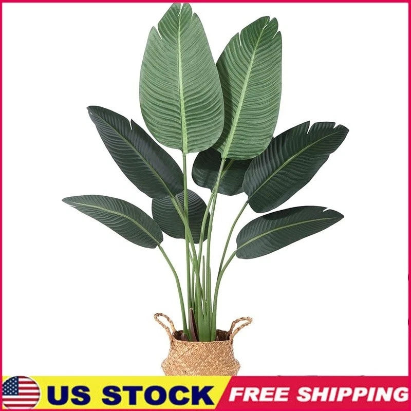 Faux bird of paradise plant with broad green leaves in woven seagrass basket