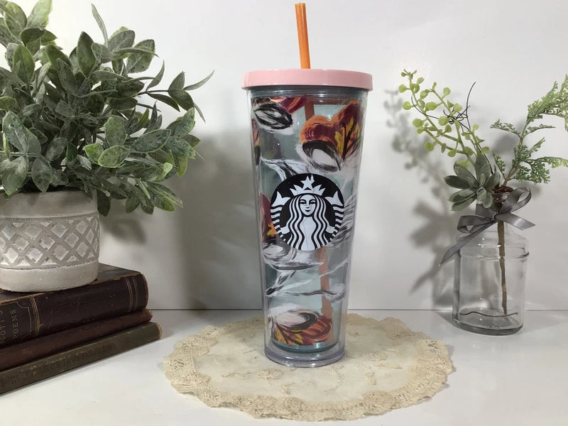 Starbucks tumbler with peony floral print, pink lid, and orange straw