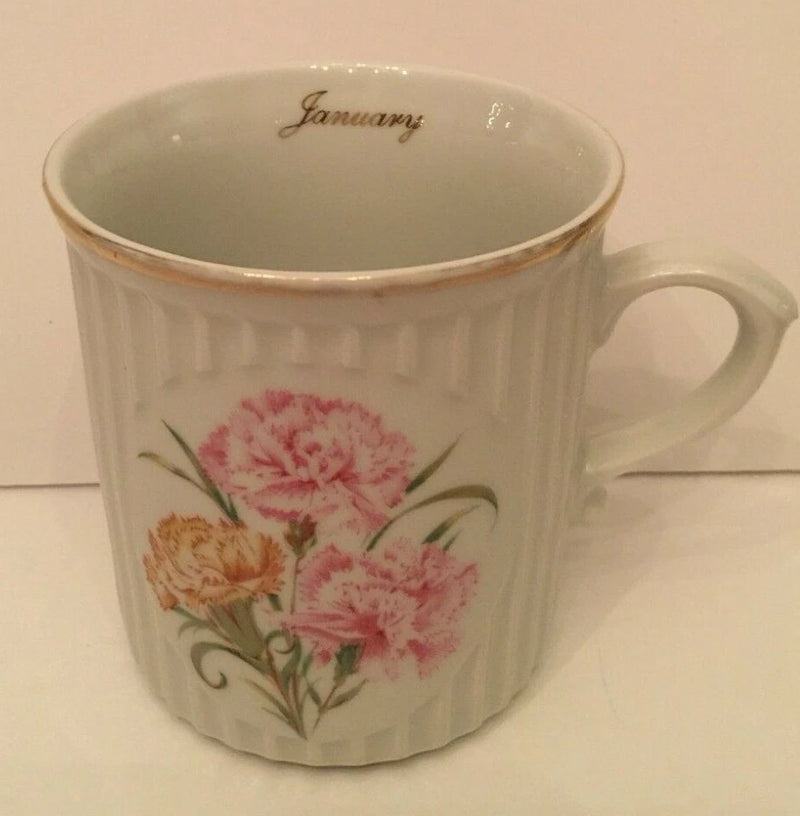 White porcelain coffee cup with pink and orange carnation floral print and 'January'