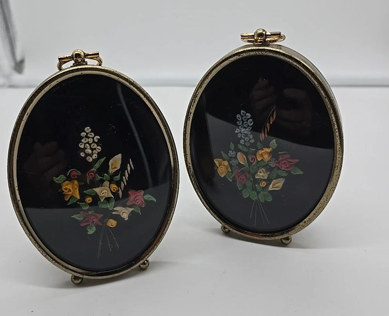 Pair of oval framed dried flower wall plaques with floral arrangement, dark backing