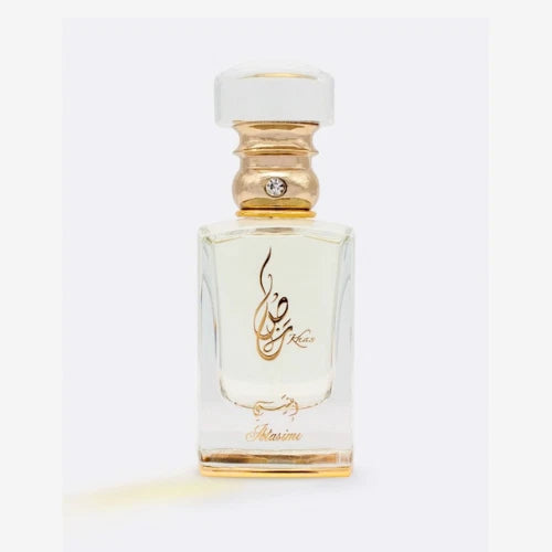 Clear glass eau de parfum bottle with gold cap and ornate label