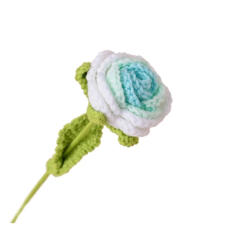 Handmade crocheted rose decor with white, teal petals and green leaf on stem