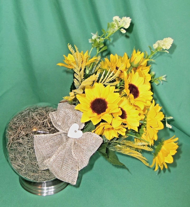 Sunflower arrangement with yellow blooms, dark centers, green foliage, and burlap ribbon bow