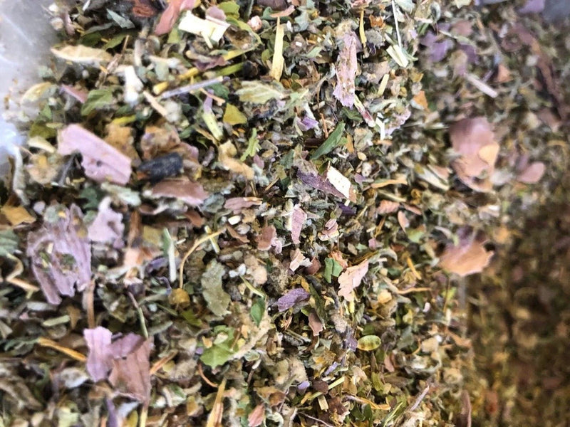 Dried herbal flower mix with purple and pink petals and green leaf bits