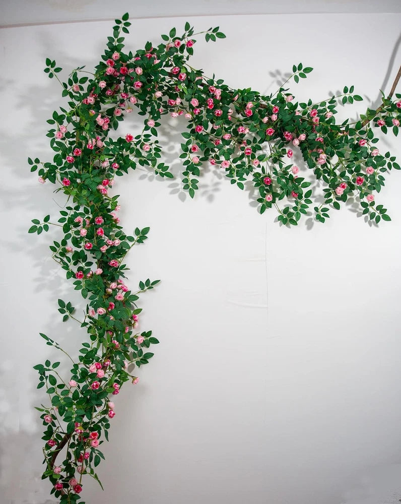 Bendable rose vine garland with pink rose-like blooms and green leaves, hanging loop