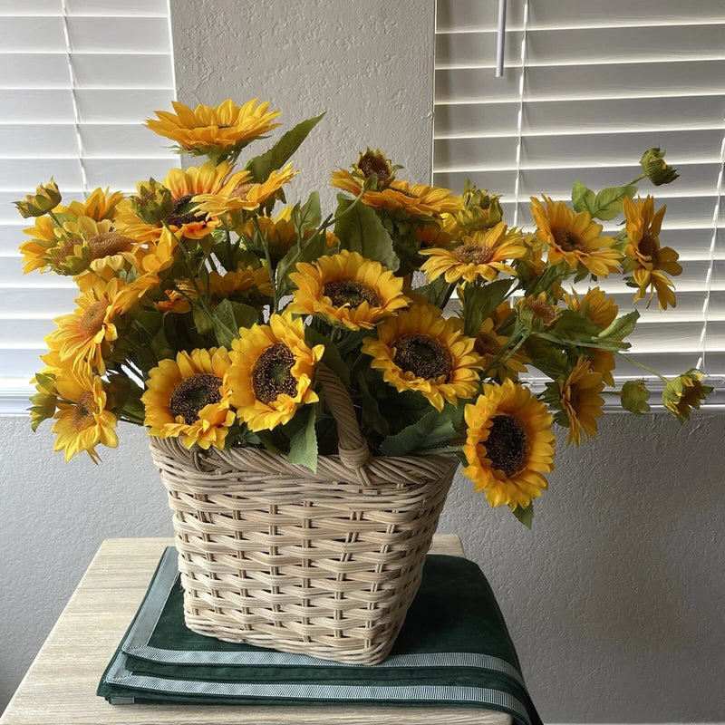 Woven wicker basket with lifelike yellow and orange silk sunflowers, green leaves