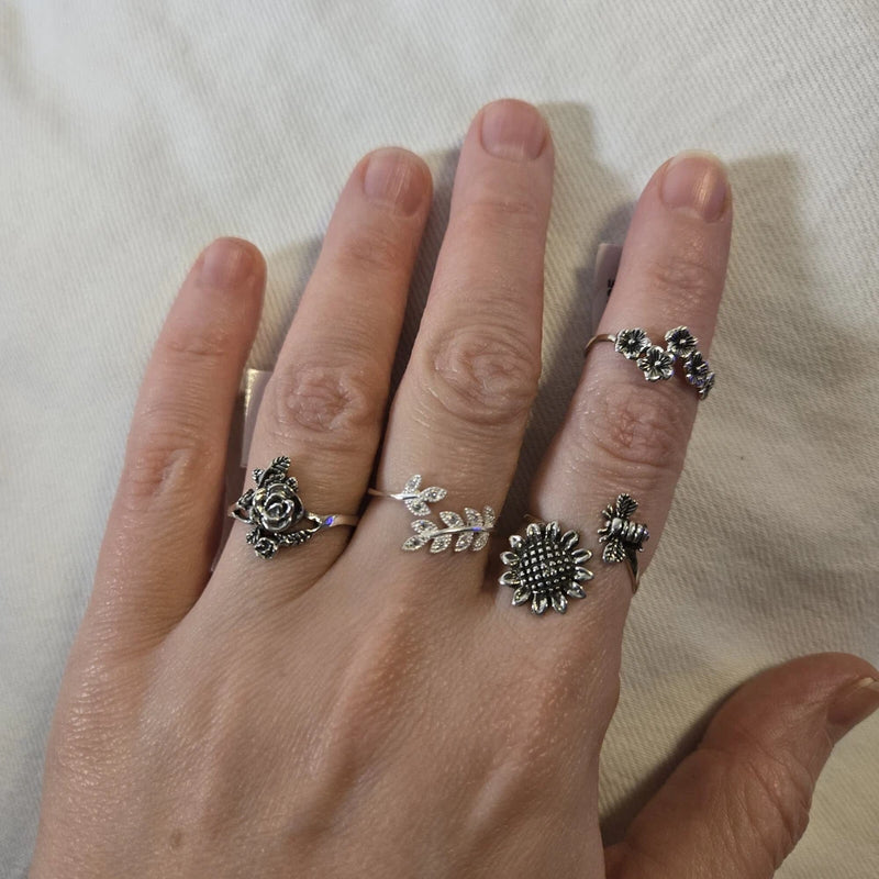 Sterling silver floral ring set with black marcasite accents, three stackable rings on hand