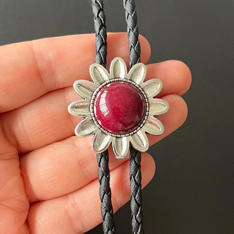 Red round jade bolo tie with silver sunflower-style bezel on braided black cord
