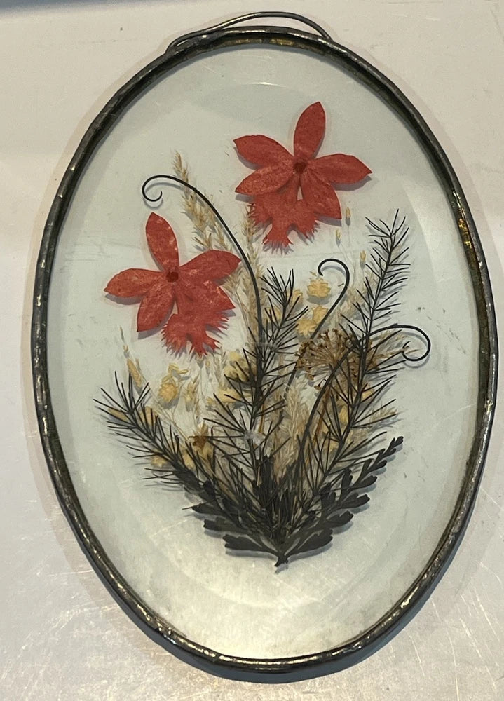 Oval metal-rim glass dried flower frame with red blooms and pressed foliage, with hanger