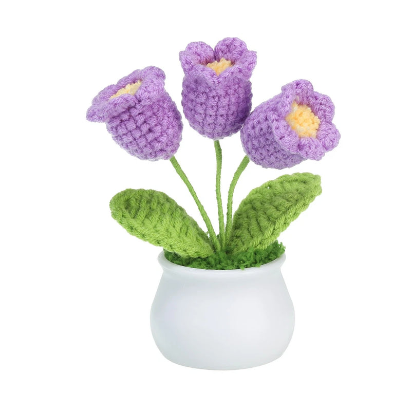 Handmade crochet flower bouquet in a small white pot, with purple blossoms and green leaves
