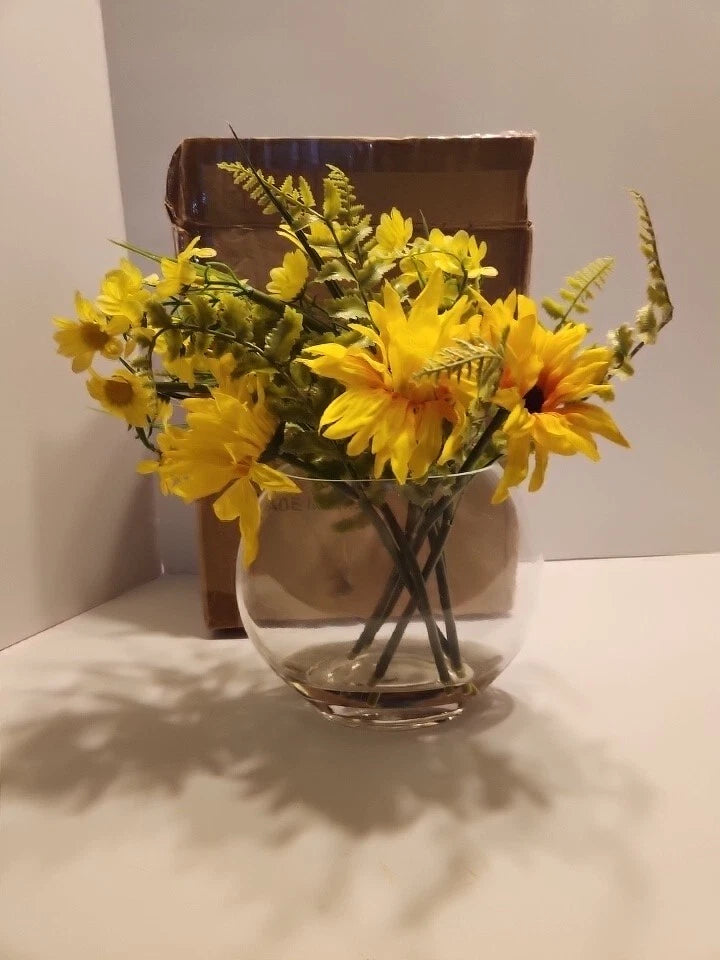 Artificial sunflower floral arrangement with yellow blooms and green stems in clear glass vase