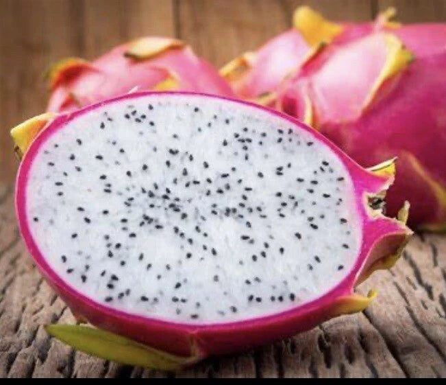 Dragon fruit slice with white flesh and black seeds, pink-purple skin