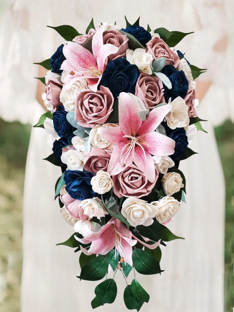 Cascading bridal bouquet with pink lilies, navy roses, and green leaves