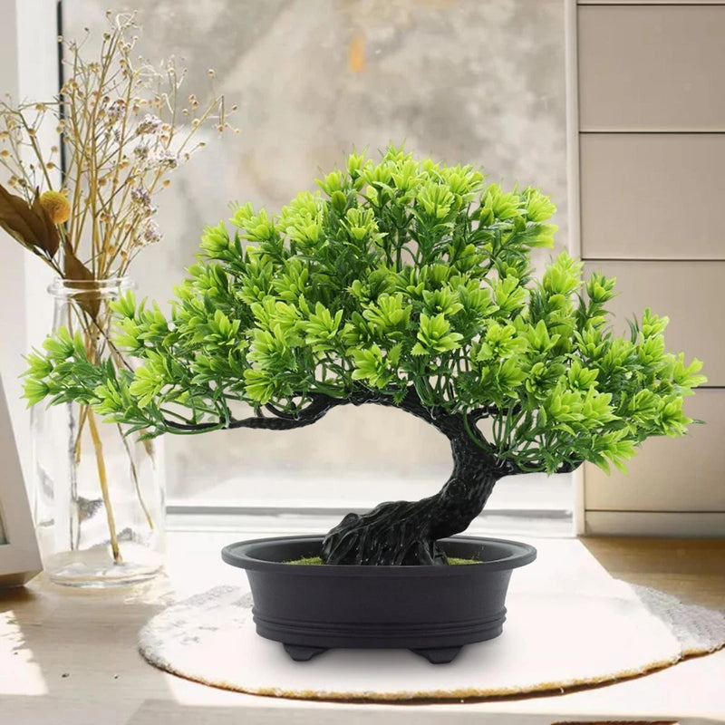 Artificial bonsai tree with bright green leaves and dark textured trunk in black pot