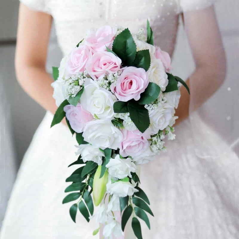 Handmade bridal bouquet with pink and white roses, green leaves, cascading stems