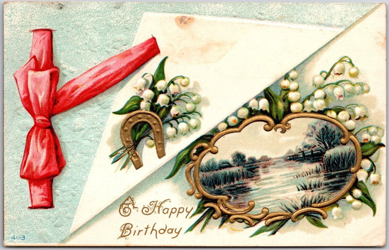 Birthday postcard with golden horseshoe, lilies of the valley, pastoral landscape and red ribbon