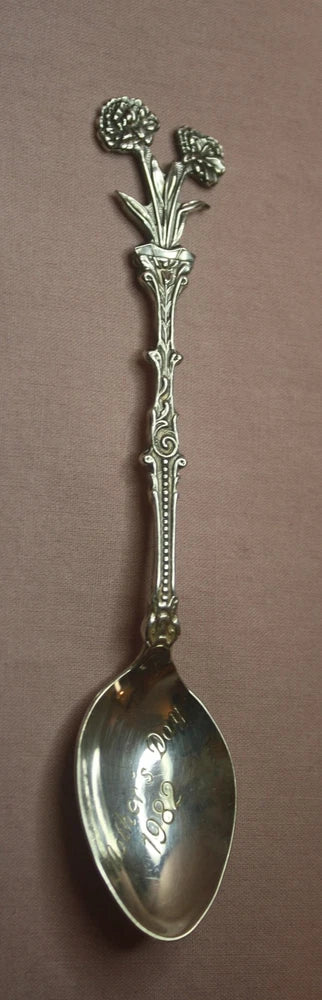 Silver-plated spoon with raised carnation flowers and ornate handle