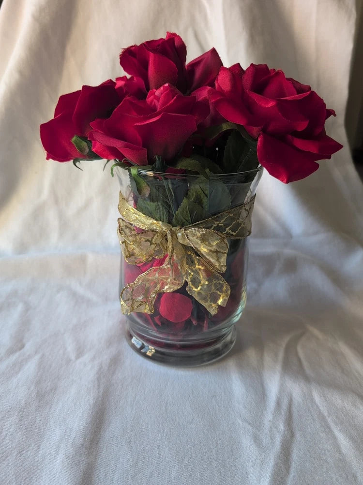 Red silk roses in clear glass vase with gold ribbon wrap