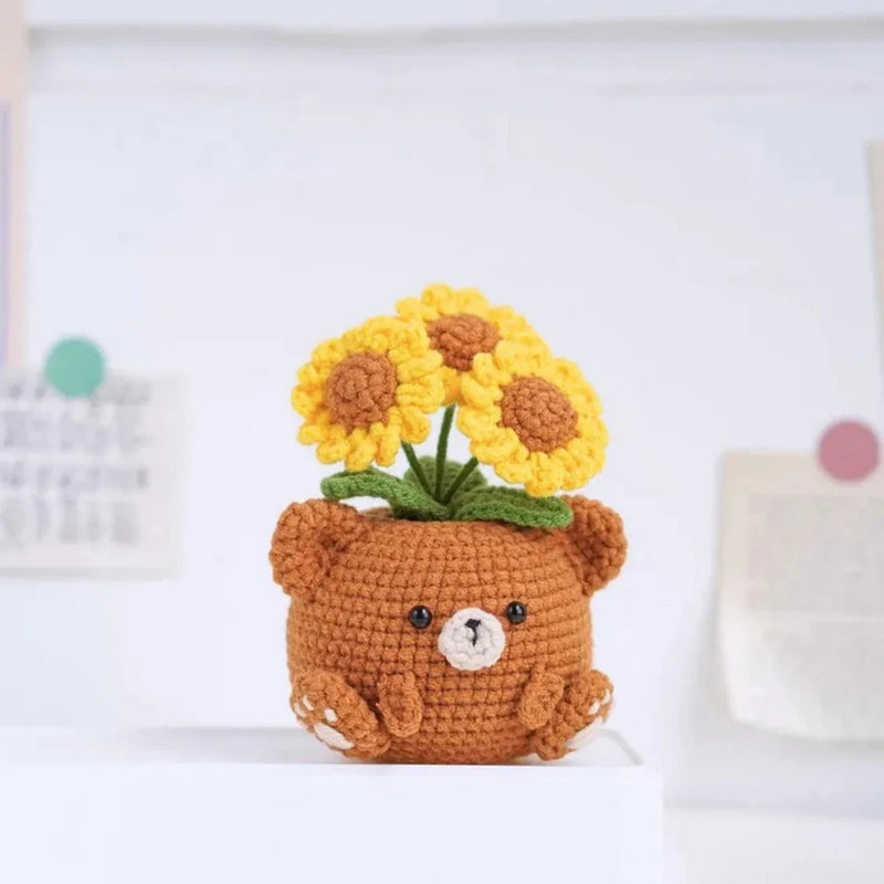 Handmade crochet amigurumi bear in a pot with yellow sunflower heads and cute face