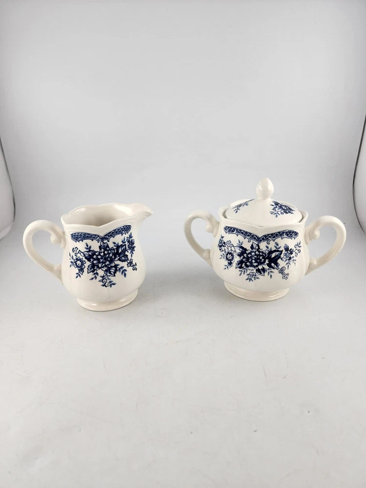 Vintage porcelain creamer and sugar bowl set, white with blue floral pattern, handles