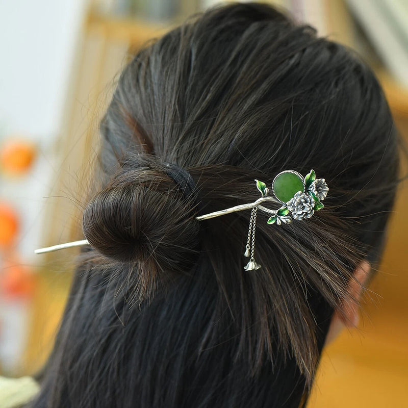 Silver-toned peony hairpin with green enamel flower and dangling tassel charms in bun
