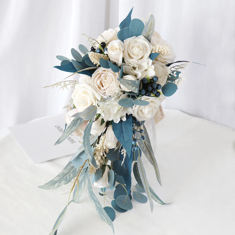 Cream and blue silk faux bouquet with white roses, blue leaves, and ribbon streamers