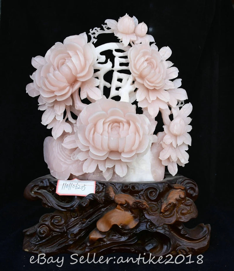 Pink jade-style peony carved wealth statue with floral relief and dark ornate base