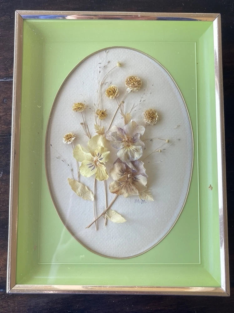 Vintage oval shadowbox with dried flowers in a dark frame
