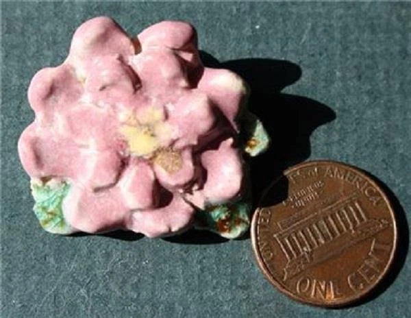 Pink carnation pottery brooch with gold-tone pin, shaped flower petals.
