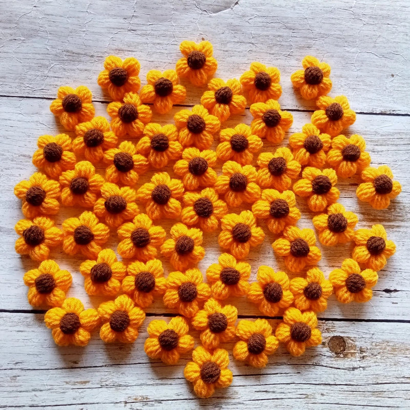 Set of handmade crochet sunflower flowers: small yellow blooms with dark brown centers.